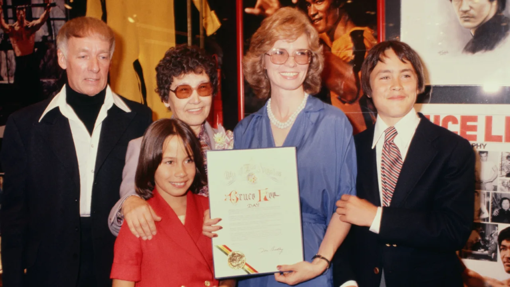 (De izquierda a derecha) Un hombre no identificado, la madre de Bruce Lee, Linda Cadwell, y sus hijos Brandon, a la derecha, y Shannon celebran el Día de Bruce Lee en 1979 en Los Ángeles. (Crédito: Archivos Michael Ochs/Getty Images)